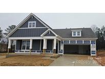 New construction home featuring gray siding, white trim, an attached garage, and a covered front porch at 231 Miramar Dr, York, SC 29745