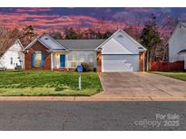 Charming single-Gathering home with brick accents, a two-car garage, and a well-manicured lawn at 2922 Emerald Meadow Ln, Charlotte, NC 28273