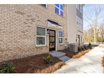 Charming brick townhome with a modern black front door and well-maintained landscaping at 3816 Odom Way, Charlotte, NC 28216
