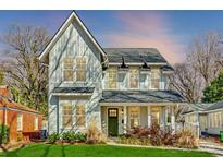 Charming two-story home with light blue siding, black trim, and lush green lawn at 412 Sylvania Ave, Charlotte, NC 28206