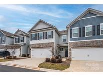 Charming townhomes featuring stone accents, two-car garages, and well-maintained landscaping at 4242 Plumeria Way, Fort Mill, SC 29707