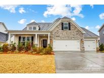 Charming home with a stone facade, three-car garage, and manicured landscaping at 6858 Hunts Mesa Dr, Fort Mill, SC 29707