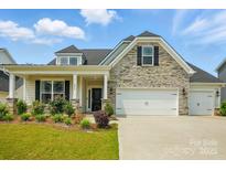 Charming home with stone accents, inviting curb appeal, and a two car garage at 6858 Hunts Mesa Dr, Fort Mill, SC 29707