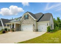 Charming home with stone accents, inviting curb appeal, and a two car garage at 6858 Hunts Mesa Dr, Fort Mill, SC 29707