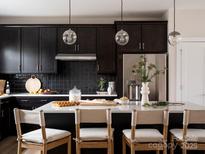 Modern kitchen features a large island with white countertops and stylish pendant lighting at 7003 Impulse Ct, Charlotte, NC 28205