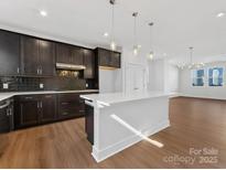 Modern kitchen boasts dark cabinetry, stainless appliances, quartz counters, and a large island at 7003 Impulse Ct # 60, Charlotte, NC 28205