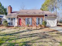Charming one-story brick home featuring blue shutters and a well-maintained front yard at 7300 Carrbridge Ln, Charlotte, NC 28226