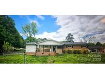 Charming single-story home with a welcoming front porch and well-maintained landscaping at 1024 Old Mountain View Rd, Mount Holly, NC 28120