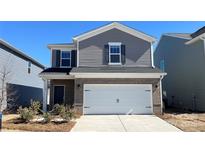Charming two-story home with gray siding, brick accents, and a two-car garage at 1105 Harry Ct, Albemarle, NC 28001