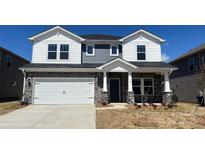 Charming two-story home with a two-car garage, stone accents, and a well-manicured front lawn at 145 Shepherds Landing Dr, Mooresville, NC 28115