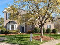 Charming two-story brick home with a well-manicured lawn and beautiful landscaping at 2020 Holly Villa Cir, Indian Trail, NC 28079
