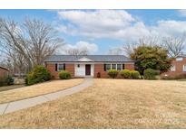 Charming red brick home with a well-manicured lawn and inviting walkway at 302 Peach St, Shelby, NC 28150