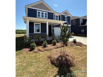 Charming two-story home with a welcoming front porch and beautifully landscaped front yard at 334 Knotty Wood Dr # 68, Monroe, NC 28110