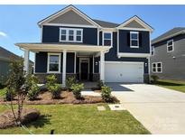 Two-story home featuring a two-car garage, covered porch and nicely landscaped yard at 334 Knotty Wood Dr # 68, Monroe, NC 28110