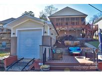 Lake house exterior featuring a lakeside patio, boat storage, and additional outdoor living space at 3542 Pinehaven Dr, Badin Lake, NC 28127