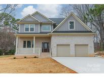 Charming two-story home featuring a brick facade, covered porch, and a two-car garage at 5125 Isaac Dr, Charlotte, NC 28216