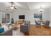 Bright living room featuring vaulted ceilings, hardwood floors, and modern furnishings at 6792 Mallard Park Dr, Charlotte, NC 28262
