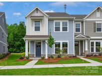 Charming two-story townhome with light blue siding, well-maintained lawn, and inviting front porch at 10113 Mamillion Dr, Huntersville, NC 28078