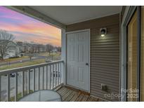 Cozy balcony with wood decking and views of the surrounding neighborhood under a lovely sunset at 1036 Plaza Walk Dr, Charlotte, NC 28215