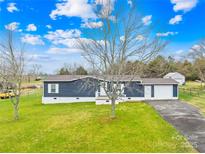Charming home with a well-maintained lawn, inviting front porch and attached garage at 133 Hallmark Estates Dr, Statesville, NC 28625