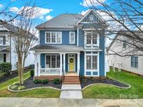 Charming two-story blue home featuring a welcoming front porch and well-manicured landscaping at 431 Third Baxter St, Fort Mill, SC 29708