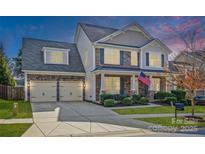Charming two-story home with stone and siding, a well-manicured lawn, and a two-car garage at 9012 Krestridge View Dr, Huntersville, NC 28078
