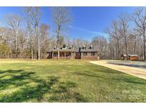 Charming brick home featuring dormer windows, a welcoming front porch, and a spacious front yard at 9414 Machado Dr, Indian Trail, NC 28079
