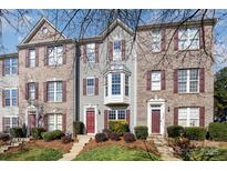 Charming townhome with brick and siding, featuring red shutters and manicured landscaping for curb appeal at 9534 Blossom Hill Dr, Huntersville, NC 28078
