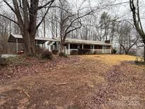 Ranch home with a covered carport and a front porch with white railings on a large lot at 1031 Cheatham Ford Rd Cheatham Ford Rd, Hiddenite, NC 28636