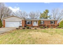 Charming brick ranch home with an attached garage and a well-maintained front yard with mature landscaping at 137 Dellinger Dr, Statesville, NC 28625