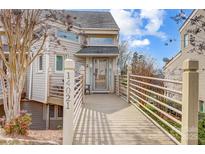 Inviting home exterior featuring a welcoming walkway, beige siding, and charming architectural details at 14021 Queens Harbor Rd, Charlotte, NC 28278