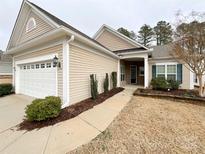 Charming single-story home with a two-car garage, manicured landscaping, and a well-maintained lawn at 2023 Moultrie Ct, Fort Mill, SC 29707
