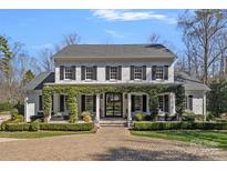 Stunning two-story white brick home featuring black shutters and inviting front porch with brick pavers at 3212 Lazy Branch Rd, Charlotte, NC 28270