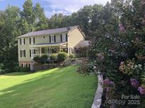 Charming two-story home with a lovely landscaped yard and inviting front porch at 591 Bent Oak Trl, Concord, NC 28027