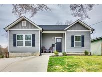 Charming gray home with black shutters, inviting front porch and well-maintained landscaping at 611 N York St, Gastonia, NC 28052