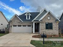 Charming one-story brick home with a two-car garage and well-manicured lawn at #92 Silver Trace Ln, Denver, NC 28037