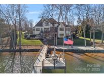 Aerial shot of a lakeside home with a dock, manicured lawn, and mature trees at 122 N Longfellow Ln, Mooresville, NC 28117