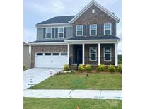 Two story home features a brick facade, two car garage and well manicured front lawn at 13705 Roderick Dr # 194, Huntersville, NC 28078