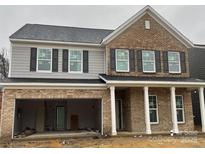 Two-story home featuring a brick facade, gray siding, black shutters, and an attached two-car garage at 13705 Roderick Dr # 194, Huntersville, NC 28078