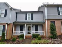 Charming townhome featuring brick accents, a covered porch, and manicured landscaping at 1536 Cooper Ave, Kannapolis, NC 28081