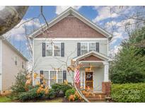 Charming two-story home with gray siding, shingle accents, manicured landscaping, and inviting front porch at 16415 Kelly Park Cir, Huntersville, NC 28078