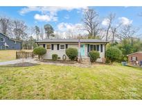 Charming single-story home with a well-manicured lawn and an inviting light-blue front door at 206 Point Cir, Belmont, NC 28012