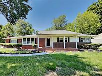 Charming brick home featuring a covered front porch, white columns, and a well-maintained front yard at 2338 Linwood Rd, Gastonia, NC 28052