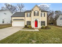 Two story home with a bright red door and well maintained landscaping at 2432 Celosia Dr, Charlotte, NC 28262