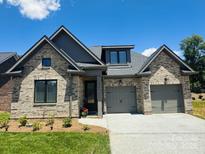 Beautiful brick home featuring a two-car garage and well-manicured lawn on a sunny day at 32 Shanklin S Ln # 32, Denver, NC 28037