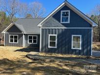 New construction home showing the gray vertical siding, shake shingle siding, white trim, and concrete driveway at 5506 Army Rd, Marshville, NC 28103