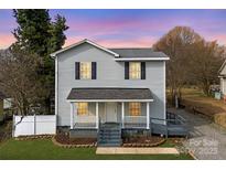 Charming two-story home with gray siding, black shutters, and a welcoming front porch at 590 Main Sw St, Concord, NC 28027