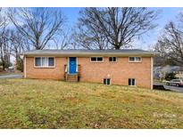 Brick home featuring a blue front door, windows and lawn at 7047 Cheyenne Dr, Charlotte, NC 28262