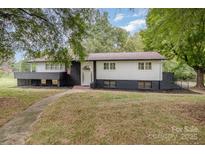 Charming home with black brick accents, white siding, a covered porch, and mature landscaping at 7407 Forney Hill Rd, Denver, NC 28037