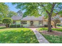 Charming white house with lush front yard, sidewalk leading to the front door at 7613 Whistlestop Rd, Charlotte, NC 28210
